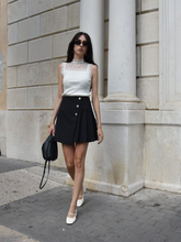 A lady wears a top and a skirt